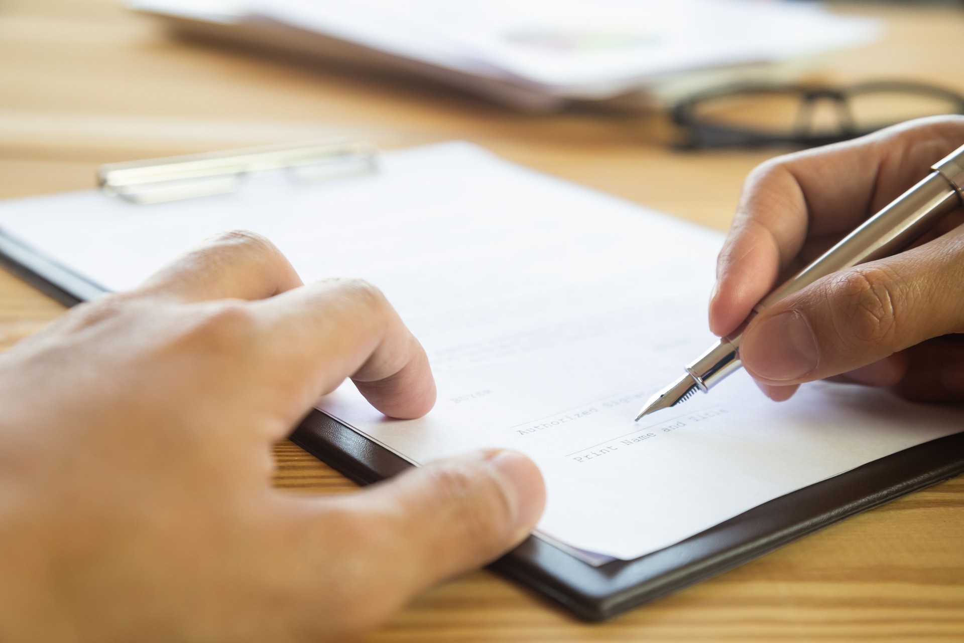 Business man signing a contract. Owns the business sign personally,director of the company, solicitor. Real estate agent holding house, moving home or renting property, merger and acquisition concept.